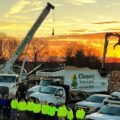 The Clauser Tree Care team posing in front of their equipment in the evening.